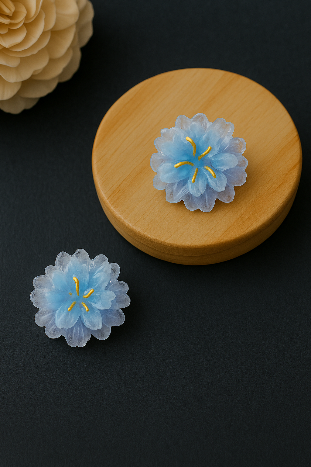 Blue flower-shaped objects on a wooden lid against a black background