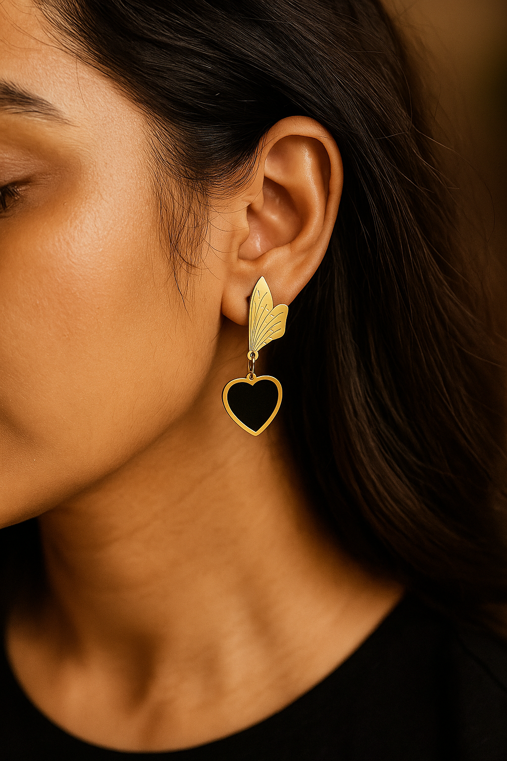 Contemporary black heart dangle earrings in gold finish with anti-tarnish coating, perfect for modern styling.