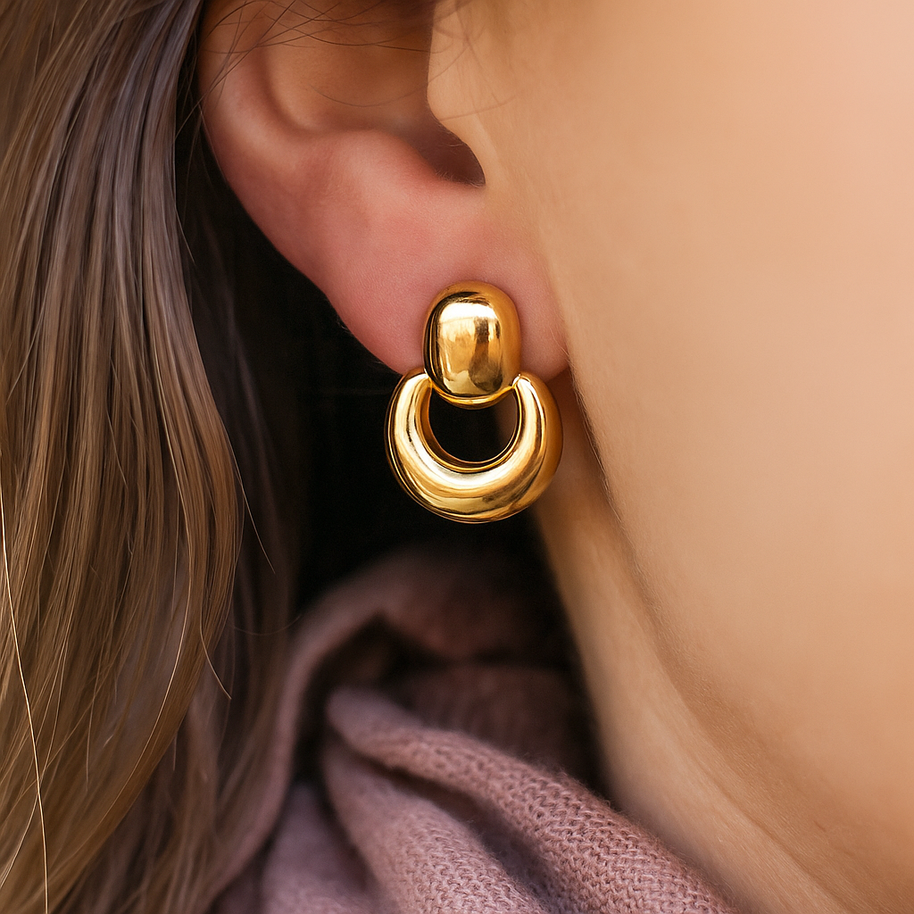 Contemporary chunky gold earrings featuring a top stud and thick rounded hoop, modern minimalist design