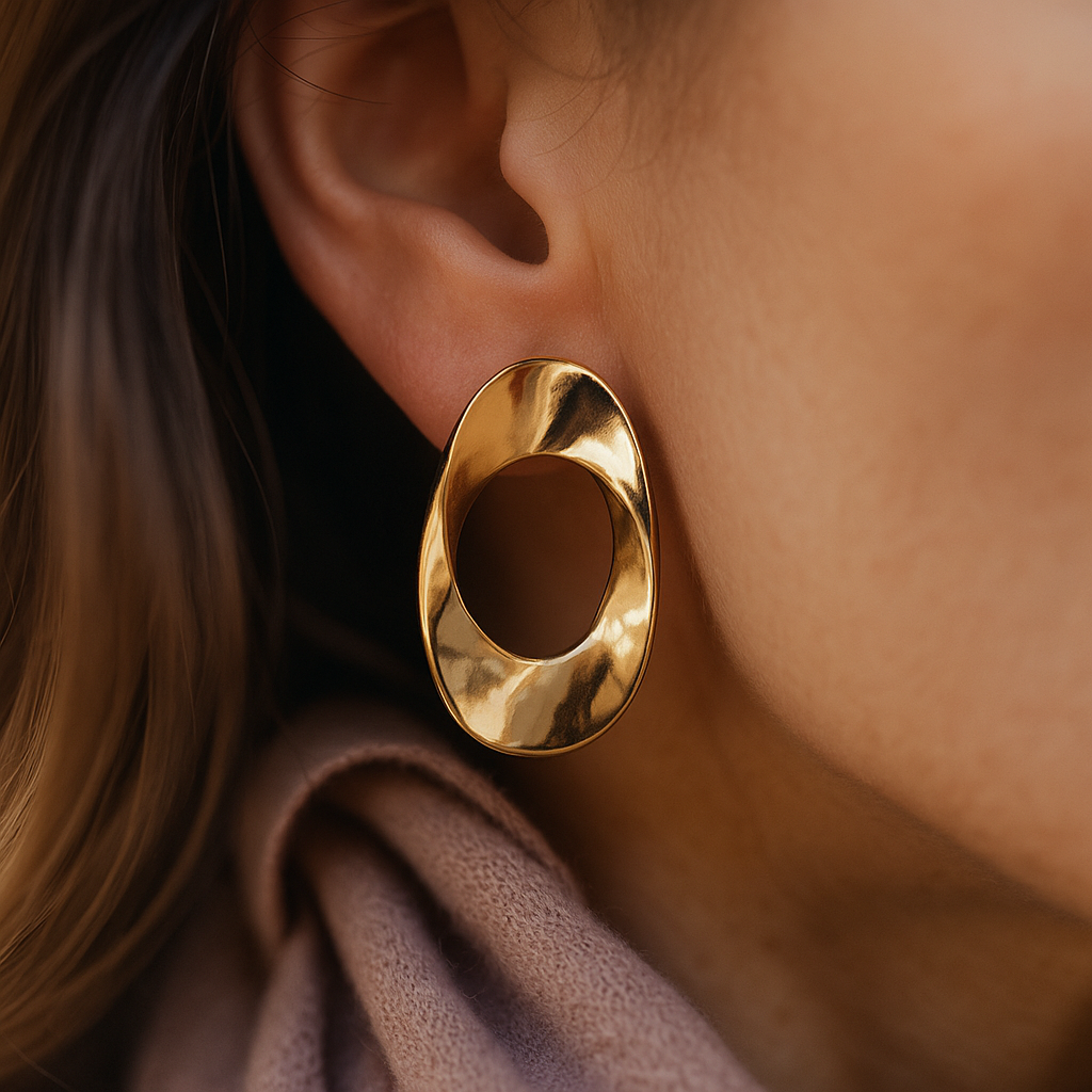 Elegant oval-shaped twisted gold earrings, high-shine designer accessory for festive outfits and modern ethnic styling