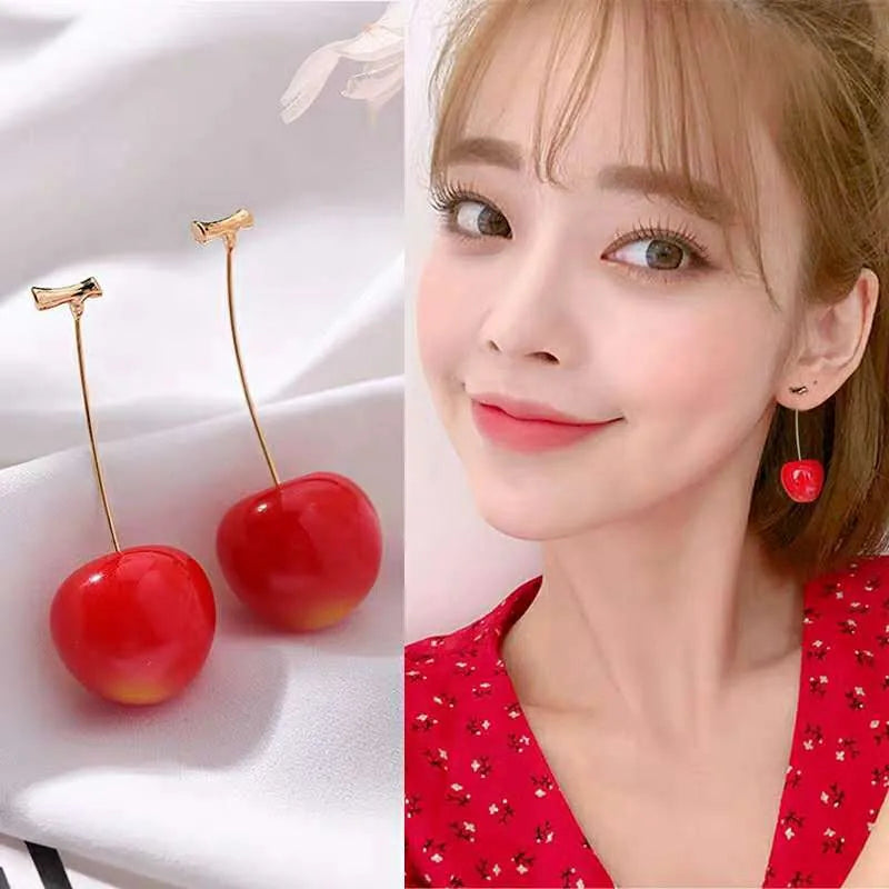 Cherry-shaped earrings on a white background with a model wearing them.