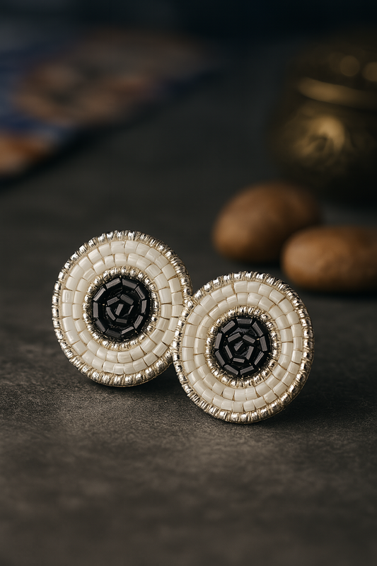 Handmade circular beaded earrings with black center and white seed bead detailing