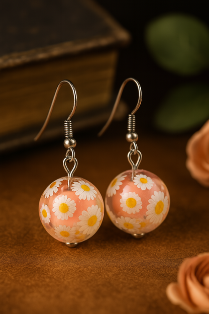 Boho-style handmade earrings with transparent peach domes and daisy flower details