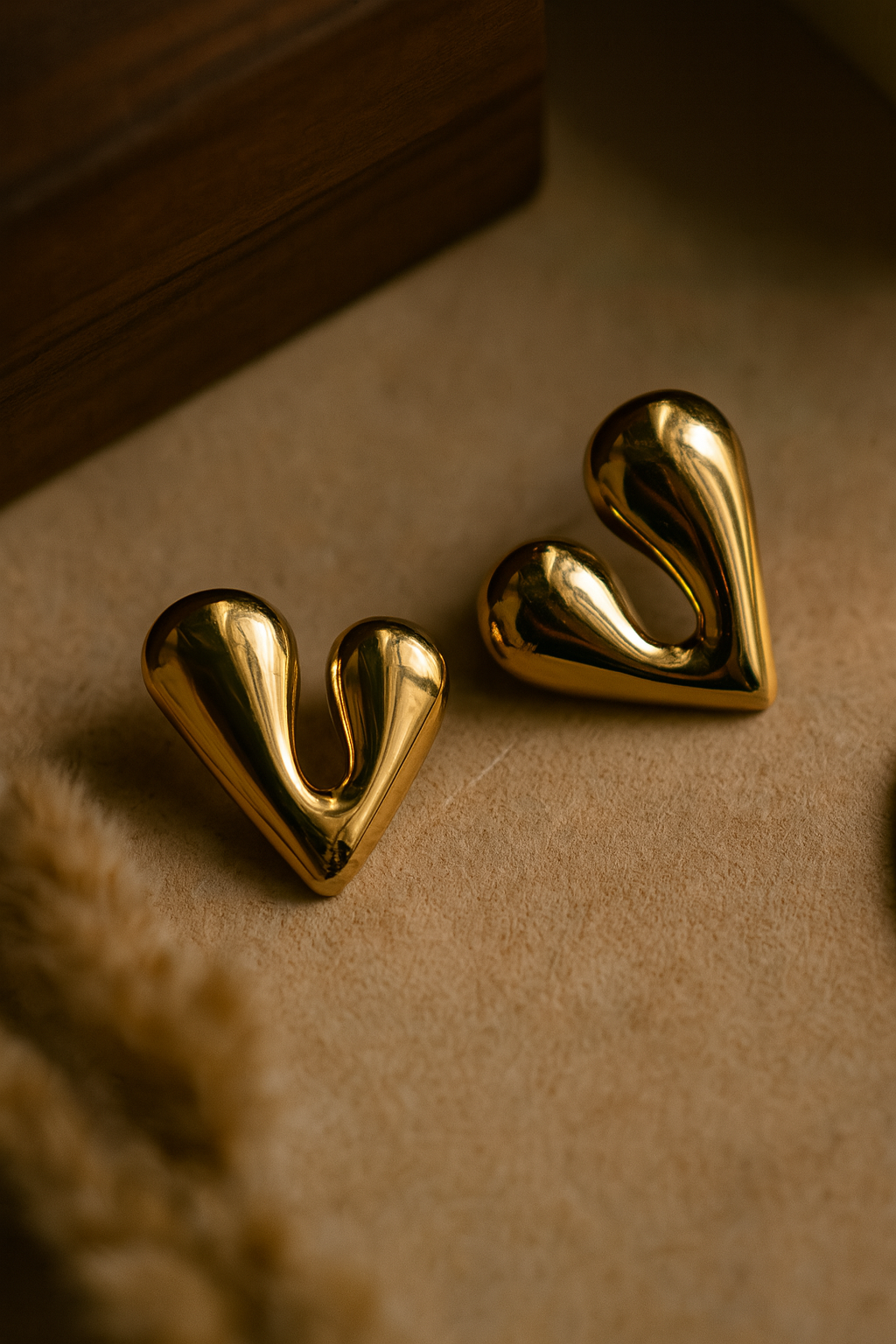 Bold heart-shaped gold earrings with sculptural, fluid design, statement jewelry ideal for festive fashion and gifting