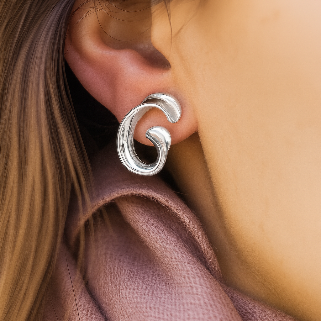 High-polish silver statement earrings with fluid spiral form, chic accessory for fashion-forward women and occasion wear