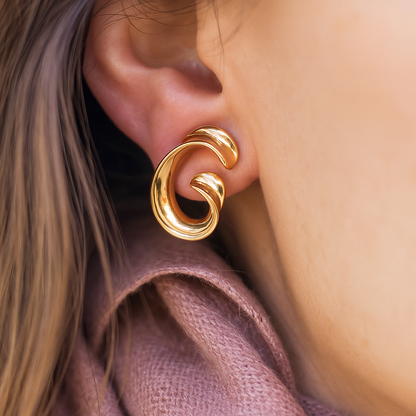 Contemporary gold-tone sculptural earrings in fluid spiral shape, luxurious accessory perfect for weddings and ethnic styling