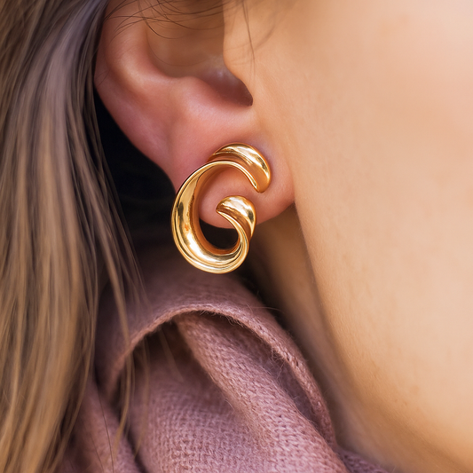 Contemporary gold-tone sculptural earrings in fluid spiral shape, luxurious accessory perfect for weddings and ethnic styling