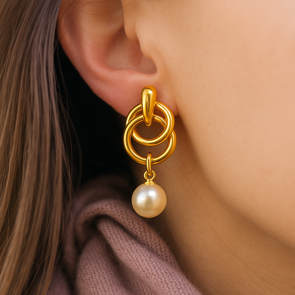 Statement anti-tarnish gold earrings featuring interlocked hoops and dangling pearl – bold accessory for festive and evening wear.