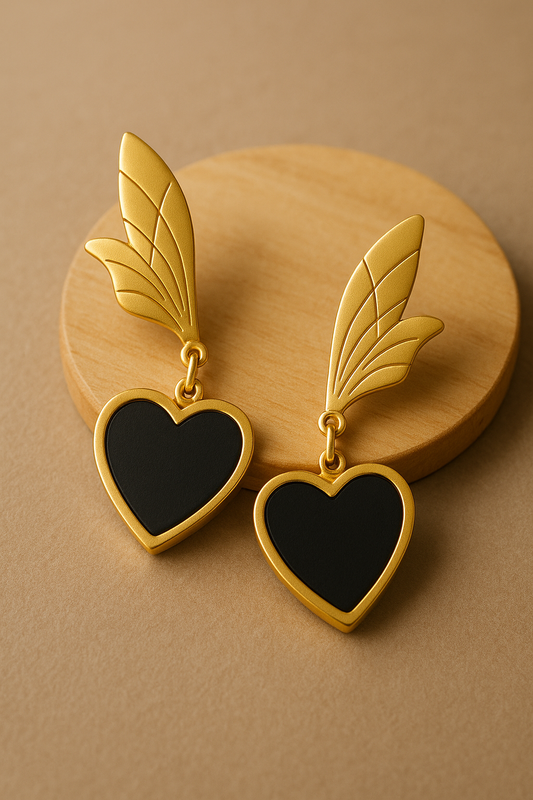 Matte gold anti-tarnish earrings with black heart drop and wing-inspired top design.