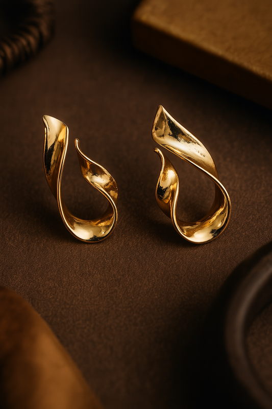 Sculptural high-shine gold earrings featuring fluid loop shape and anti-rust finish