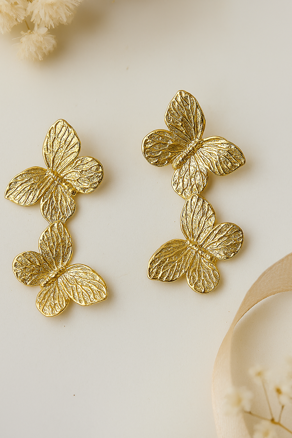 Matte gold tone cascading butterfly earrings, intricate nature inspired drop earrings, unique fashion accessory